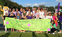  School staff holding a sign to celebrate McNeal Elementary's 20th anniversary